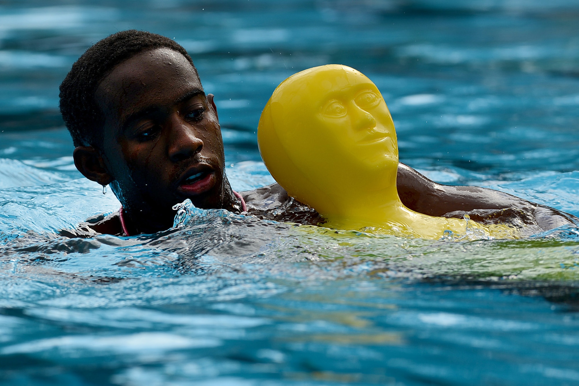 Darius Gibson, 20th Force Support Squadron lifeguard, rescues a mannequin from the pool and swims to safety during lifeguard training at the Woodland Pool, Shaw Air Force Base, S.C., July 15, 2015. Part of a lifeguard’s duty is to identify potential hazards, such as swimmers who struggle, show signs of heat exhaustion, or are behaving in an unsafe manner. (U.S. Air Force photo by Senior Airman Diana M. Cossaboom/Released)