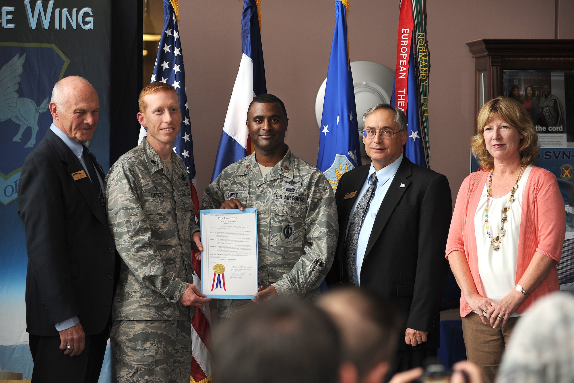 Colorado Springs City Council members Larry Bagley (left) and Andy Pico (second from right) and Katie Lally, special assistant to the mayor of Colorado Springs, present Lt. Col. Todd Benson (second from left), 2nd Space Operations Squadron commander, and Maj. Roland Rainey, 2 SOPS director of operations, with a proclamation from City Council declaring July 17, 2015 as GPS Day during a ceremony Wednesday, July 15, 2015 in the headquarters building at Schriever Air Force Base, Colorado. The proclamation is in recognition of the 20th anniversary of the declaration of full operational capability for the GPS constellation.  (U.S. Air Force photo/Dennis Rogers)