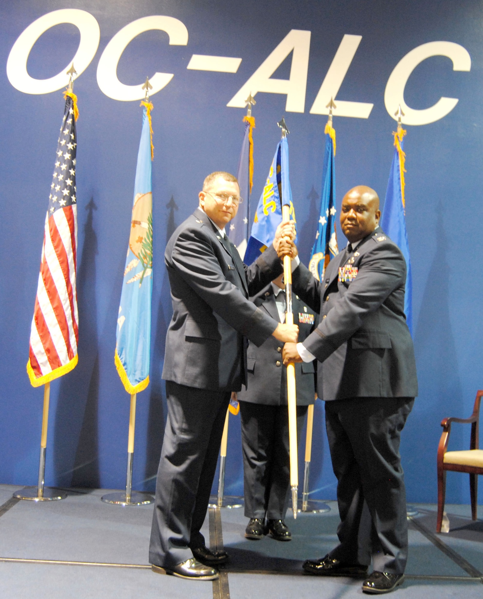 During a July 10 ceremony, Brig. Gen. Mark Johnson, Oklahoma City Air Logistics Complex commander, left, passed command of the 76th Commodities Maintenance Group to Col. Robert W. Jackson II. (Air Force photo by Kathy Paine/Released)