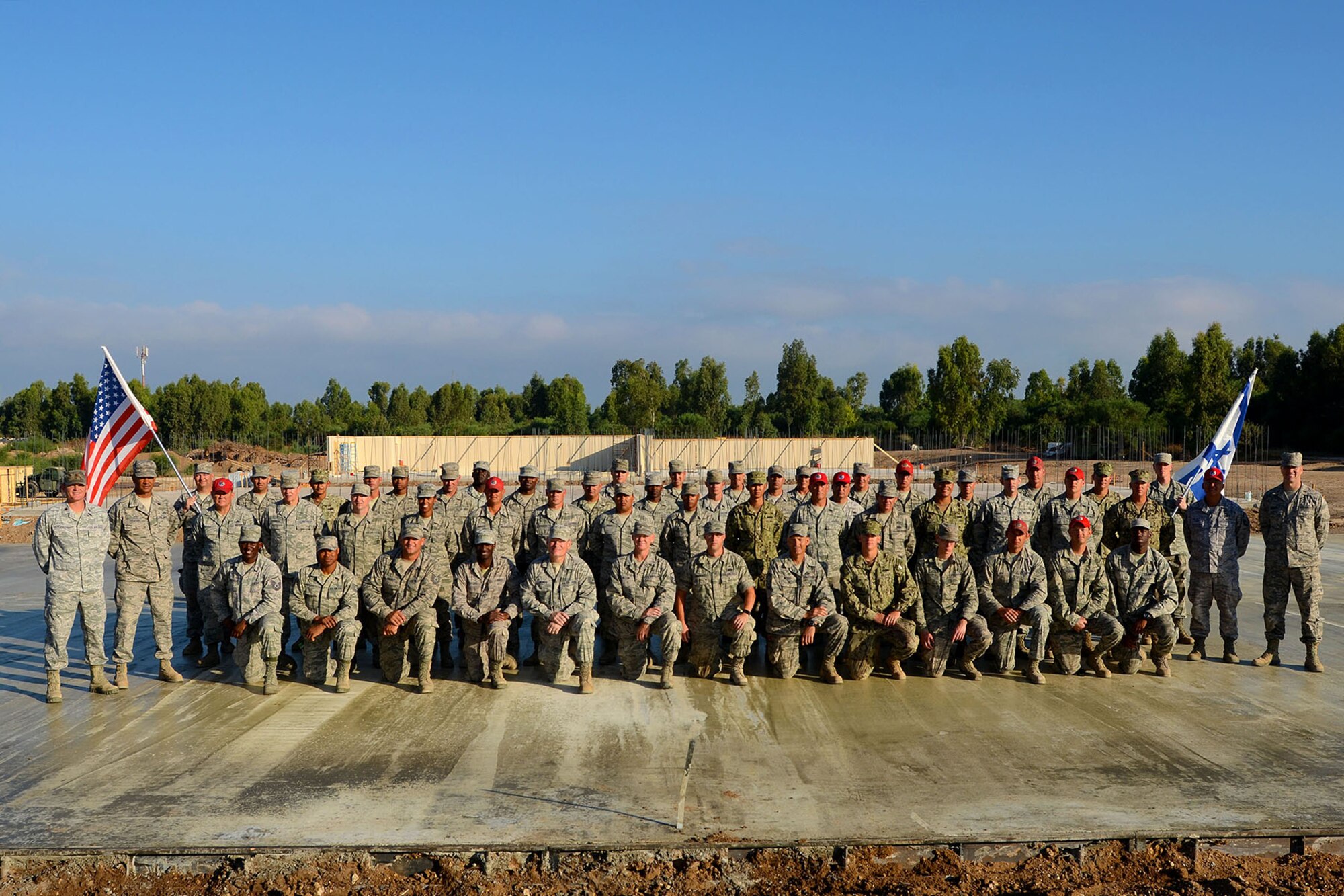 U.S. Air Force civil engineers from the South Carolina Air National Guard’s 169th Civil Engineer Squadron Prime BEEF, Ohio Air National Guard’s 200th RED HORSE Squadron and U.S. Navy SEABEES from the Naval Mobile Construction Battalion 11, pose for a photo during construction of mutli-purpose buildings in Israel, July 9, 2015. Prime BEEF Airmen are working alongside 200th RED HORSE Squadron and U.S. Navy SEABEES civil engineers during the deployment for training exercise. The construction project is to help S.C. Prime BEEF Airmen maintain their civil engineering specialties. (South Carolina Air National Guard photo by Tech. Sgt. Caycee R. Watson / RELEASED)