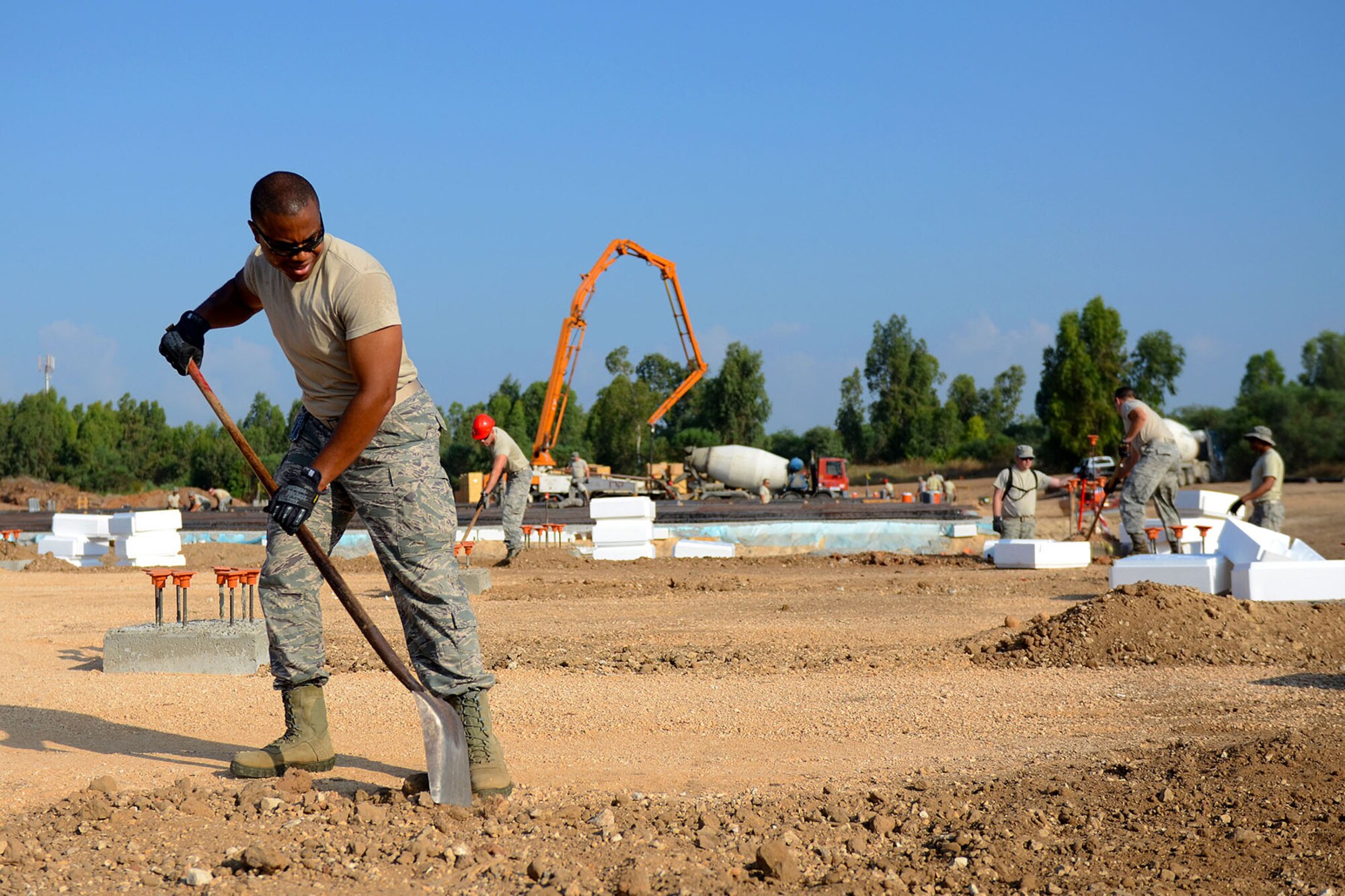 U.S. Air Force Staff Sgt. Dontavious Cooper, a heating, ventilation and air-conditioning technician with the South Carolina Air National Guard’s 169th Civil Engineer Squadron at McEntire Joint National Guard Base, S.C., levels ground to lay foundations for multi-purpose buildings being constructed in support of a Deployment for Training in Israel, June 29, 2015. The construction project is to help S.C. PRIME BEEF Airmen maintain their civil engineering specialties. Swamp Fox civil engineers are working alongside 200th RED HORSE Squadron and U.S. Navy SEABEES civil engineers during the training exercise. (South Carolina Air National Guard photo by Tech. Sgt. Caycee R. Watson / RELEASED)