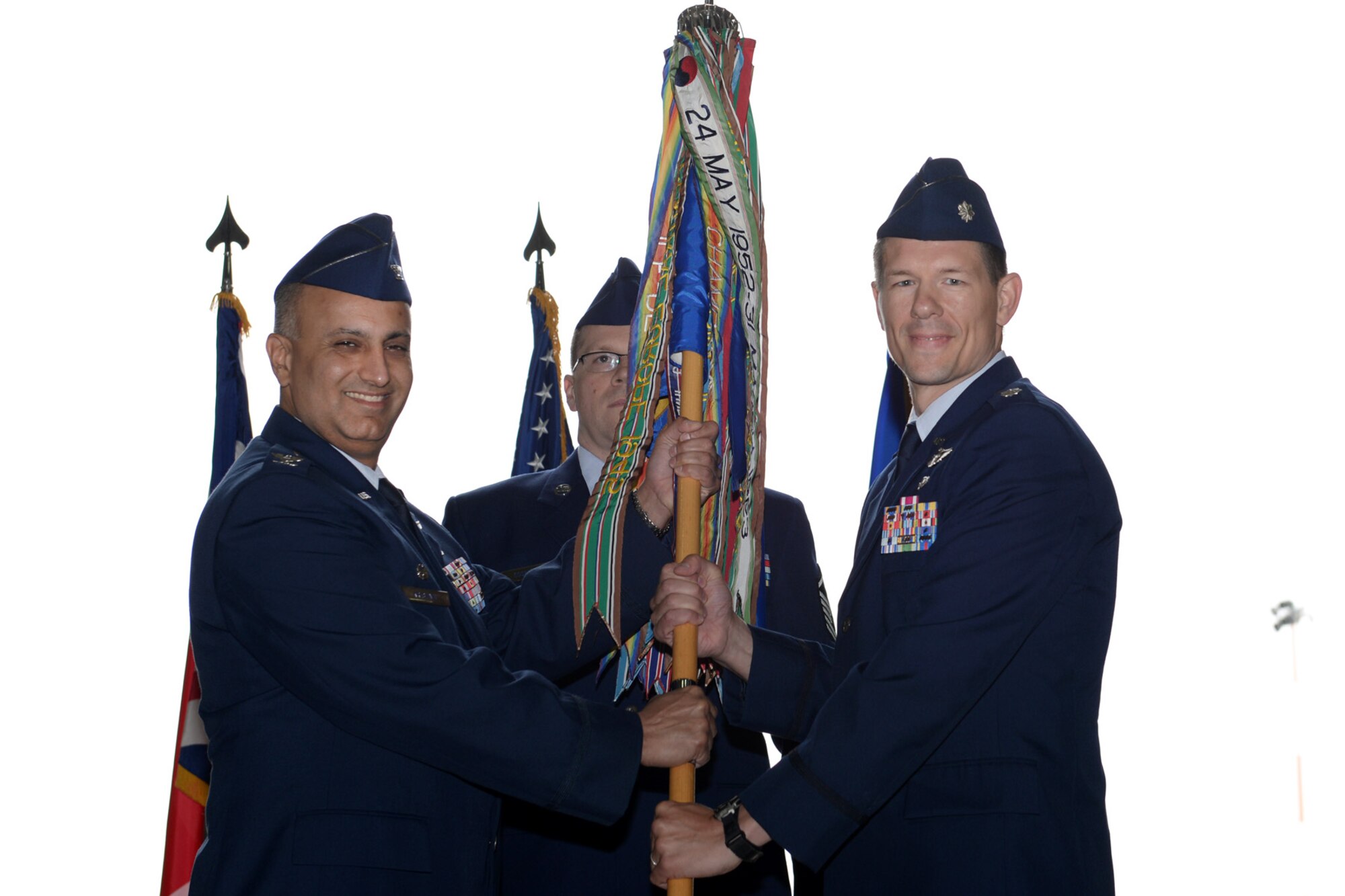 U.S. Air Force Col. Mohan S. Krishna, 55th Operations Group commander at Offut Air Force Base, Neb., passes the guidon to U.S. Air Force Lt. Col. Keith Webster, incoming 95th Reconnaissance Squadron commander, during the change of command ceremony July 15, 2015, on RAF Mildenhall, England. The passing of the unit guidon during a change of command ceremony is a symbolic representation of passing authority to the incoming commander for all to see. (U.S. Air Force photo by Senior Airman Kate Thornton/Released)