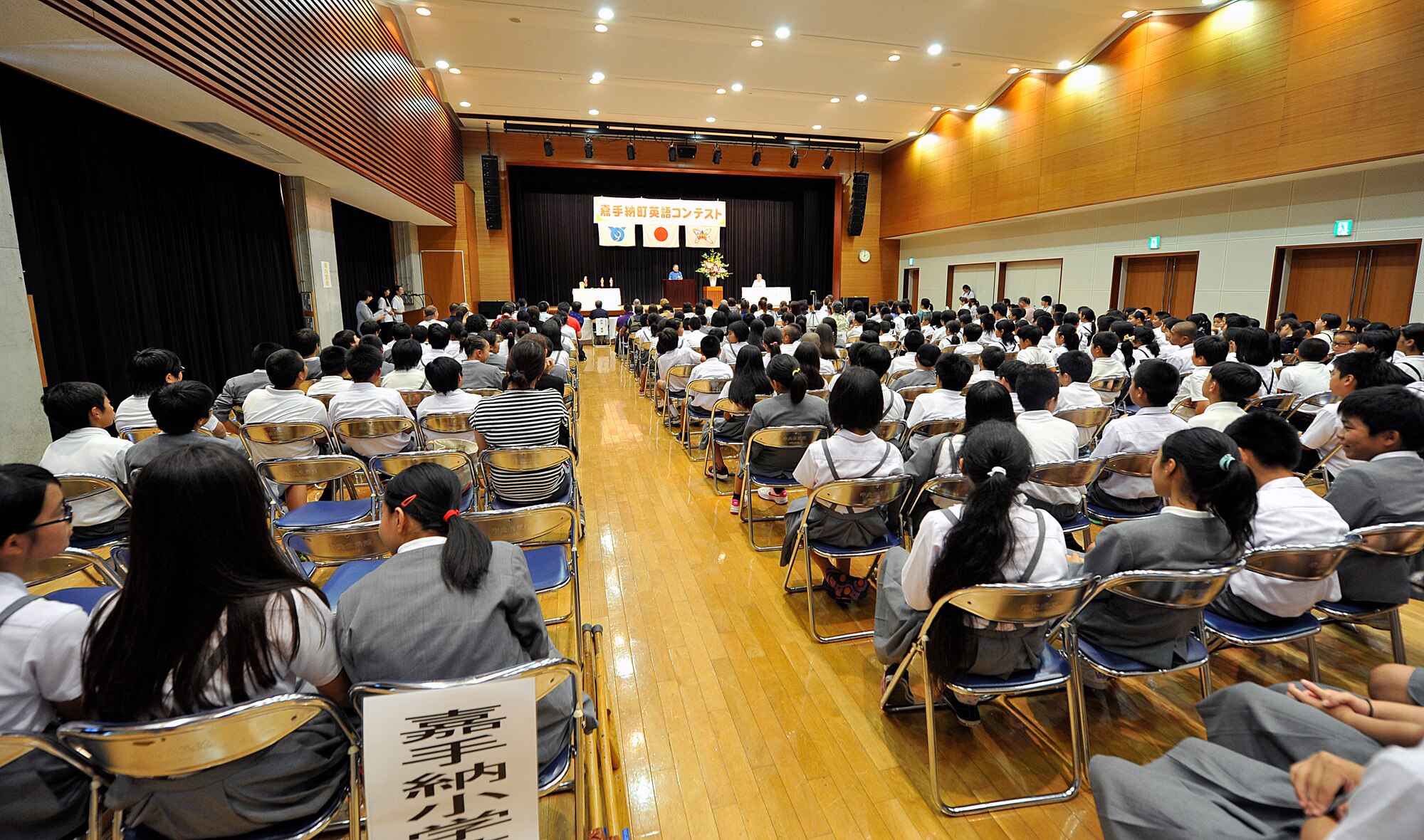 More than 200 children from elementary and junior high schools of Kadena Town and spectators attend the 18th annual English contest at the Kadena Rotary Plaza on Okinawa, Japan, July 16, 2015. Fifteen children were selected from each elementary and junior high school of Kadena Town to tell a story in English. They were scored on storytelling, pronunciation, voice of magnitude, gesture and intonation. (U.S. Air Force photo by Naoto Anazawa) 
