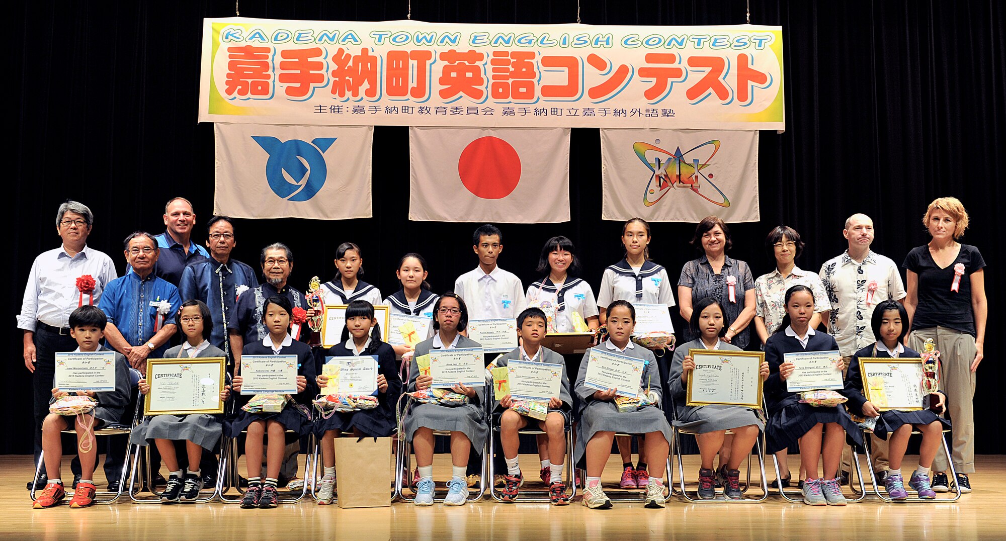 U.S. Air Force Lt. Col. Kieran Keelty, 18th Mission Support Group deputy commander (third from left), poses for a group photo with all contestants and judges after the 18th annual English contest at the Kadena Rotary Plaza on Okinawa, Japan, July 16, 2015. The goal of this contest is to give youth a chance to learn foreign languages while promoting a sense of internationalism. The Kadena leader's participation through judging and awards presentation helped further advance the relationship with the Kadena Language Institute. (U.S. Air Force photo by Naoto Anazawa)