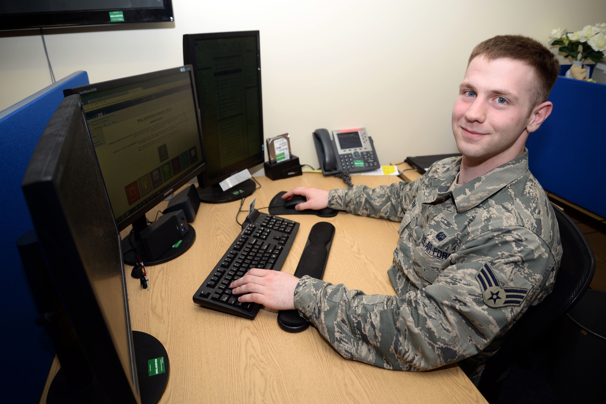 U.S. Air Force Senior Airman Ian J. Rohm 100th Communications Squadron Wing Information Assurance technician from Johnston, Ohio, poses for a photo at his desk June 8, 2015, on RAF Mildenhall, England. Rohm was awarded the Square D Spotlight for displaying the core value “Excellence in All We Do.“ (U.S. Air Force photo by Senior Airman Christine Halan/Released)