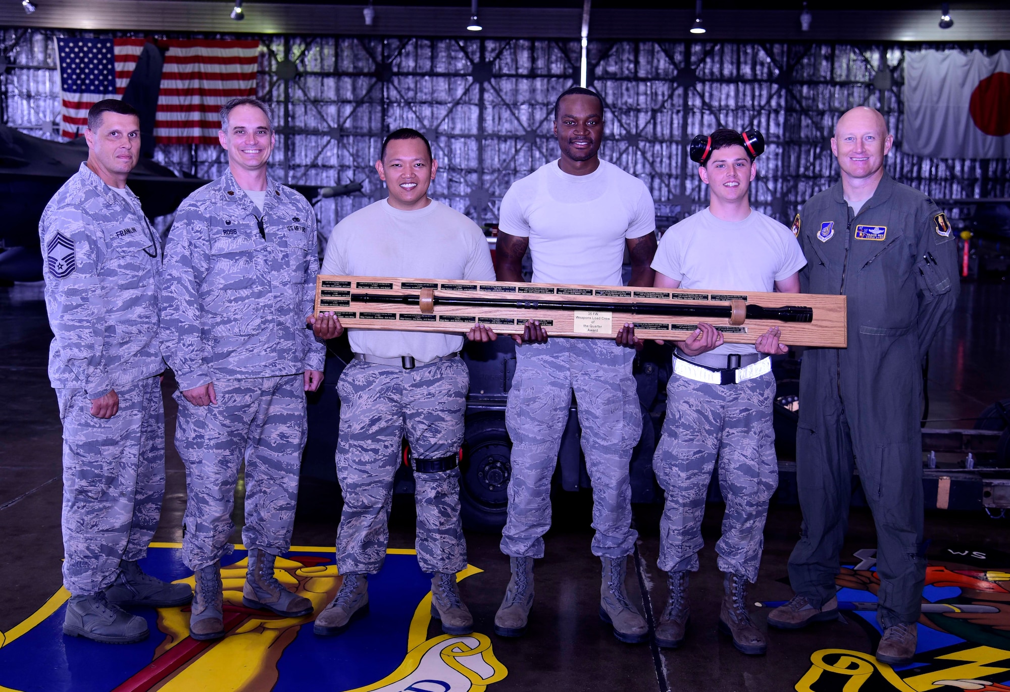 The third quarter weapons load crew competition winners from the 13th Aircraft Maintenance Unit pose with their trophy at Misawa Air Base, Japan, July 17, 2015. The winner is determined by a combined score of the physical load test and a written exam. (U.S. Air Force photo by Airman 1st Class Jordyn Fetter/Released)