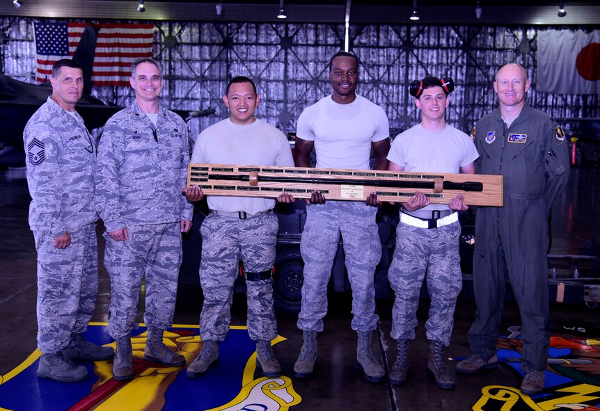The third quarter weapons load crew competition winners from the 35th Aircraft Maintenance Squadron, 13th Aircraft Maintenance Unit pose with their trophy at Misawa Air Base, Japan, July 17, 2015. The winner is determined by a combined score from a physical load test and a written exam. (U.S. Air Force photo by Airman 1st Class Jordyn Fetter/Released) 