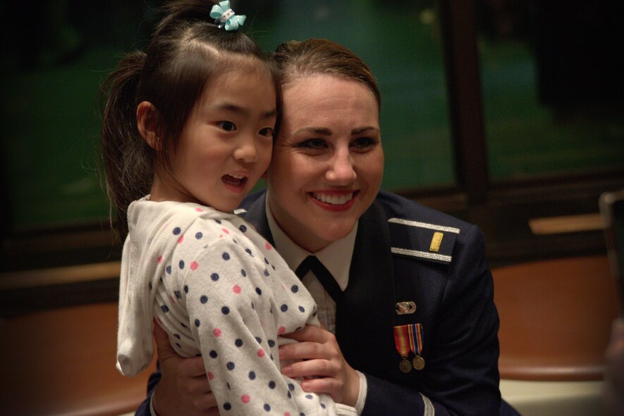 U.S. Air Force 1st Lt. Lauren Rogers, 35th Fighter Wing deputy chief of public affairs and Air Force Tops in Blue vocalist, takes a photo with a local Japanese child at the Misawa Civic Center in Misawa, Japan, July 16, 2015. An important element of Tops In Blue is its community outreach program, and the ability to positively impact communities throughout the tour. (U.S. Air Force photo by Senior Airman Jose L. Hernandez-Domitilo/Released)