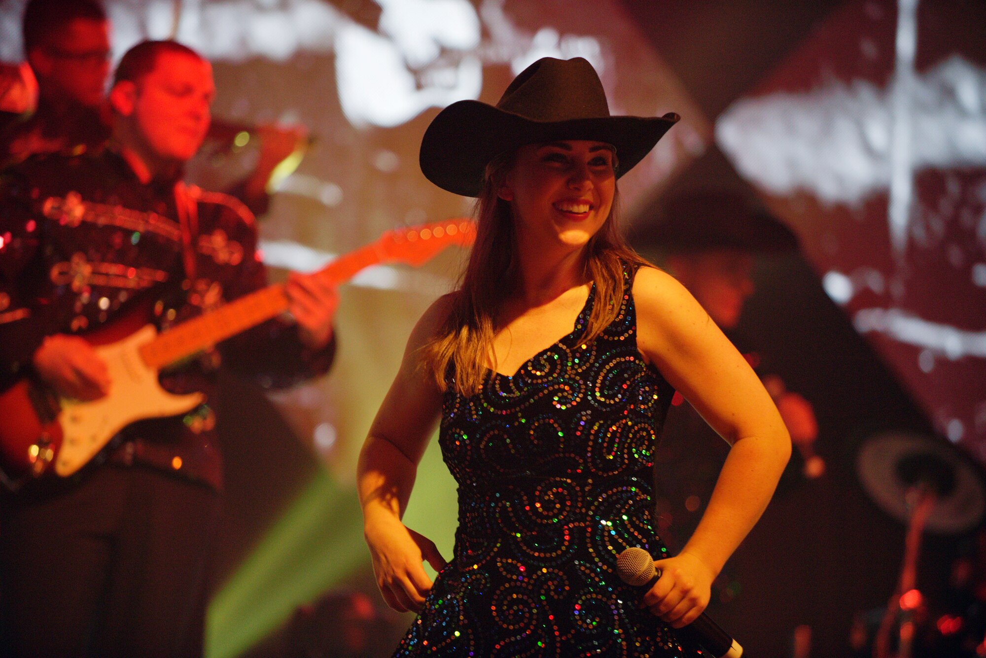 U.S. Air Force 1st Lt. Lauren Rogers, 35th Fighter Wing deputy chief of public affairs and Air Force Tops in Blue vocalist, performs and dances to a country song at the Misawa Civic Center in Misawa, Japan, July 16, 2015. Rogers was able to perform for her fellow Wild Weasels during this performance at her home station. (U.S. Air Force photo by Senior Airman Jose L. Hernandez-Domitilo/Released)