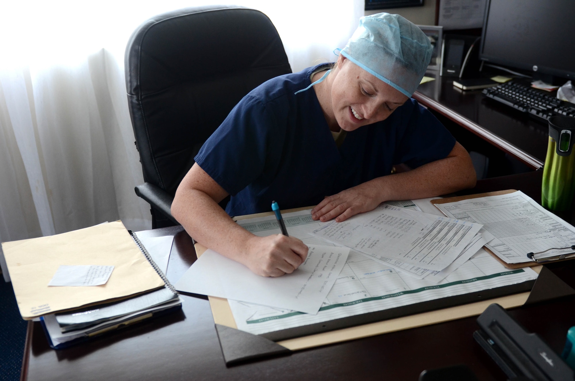 U.S. Army Capt. Dr. Annie Eure, Andersen Air Force Base Veterinary Services Branch chief, completes paperwork after a long day of work July 9, 2015 at Andersen AFB, Guam. The Andersen AFB Veterinary Treatment Facility provides care for more than 2,000 active animal patients. (U.S. Air Force photo by Airman 1st Class Alexa Ann Henderson/Released)