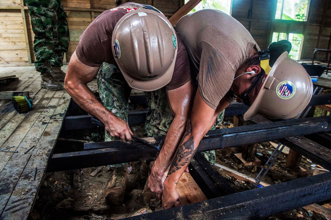 U.S. Navy Petty Officers 2nd Class Brian Whelan and Serina Espinoza repair the floor at an engineering site at a primary school during Continuing Promise 2015 in Buenaventura, Colombia, July 14, 2015. The mission involves civil-military operations.