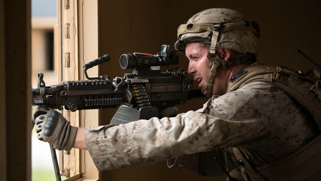 A Marine with Company G, 2nd Battalion, 2nd Marines provides cover for fellow Marines moving between buildings during a military operations in urban terrain training event at Marine Corps Base Camp Lejeune, North Carolina, July 15, 2015. Providing cover fire suppresses enemy combatants and allows the Marines to move at a reduced risk of receiving casualties.