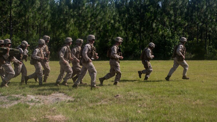 Marines with 2nd Combat Engineer Battalion and 1st Battalion, 8th Marine Regiment run toward a wall to place entryway charges during the urban breaching portion of a demolition package at Marine Corps Base Camp Lejeune, North Carolina, July 10, 2015. The demo package was conducted in preparation for an upcoming deployment, where the two units will be working together in support of Special-Purpose Marine Air-Ground Task Force Crisis Response- Africa. 