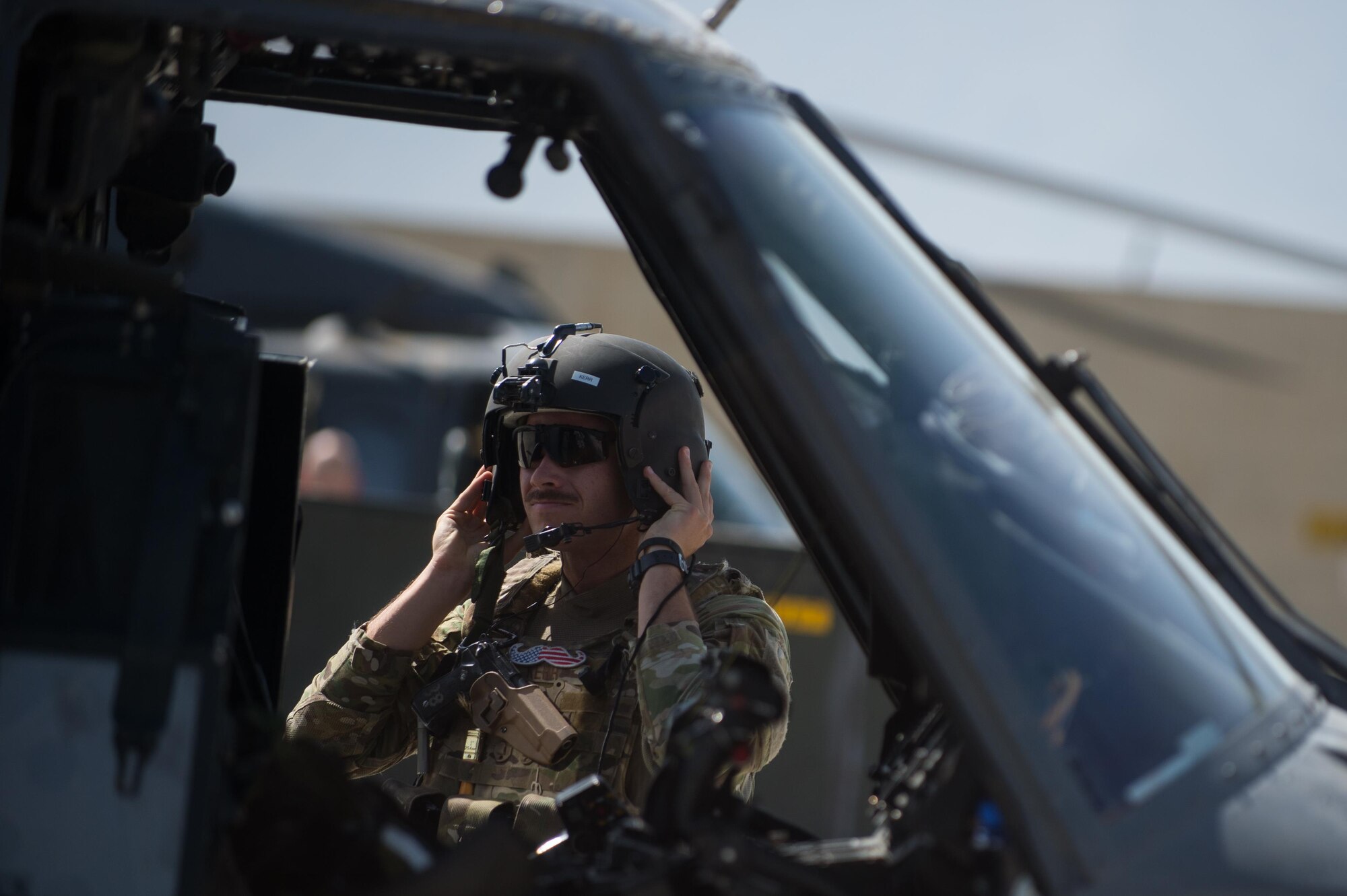 A U.S. Air Force HH-60 Pave Hawk helicopter pilot assigned to the 83rd Expeditionary Rescue Squadron puts on his helmet before a training mission at Bagram Airfield, Afghanistan, July 16, 2015. The mission of the 83rd ERQS is to rescue, recover, and return American or allied forces in times of danger or extreme duress.  (U.S. Air Force photo by Tech. Sgt. Joseph Swafford/Released)