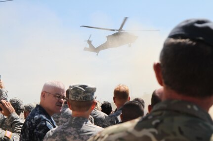 U.S. and foreign armed forces watch a simulated medical evacuation during the Distinguished Visitors (DV) day at Fort McCoy, Wis., June 19, 2015. DV day is facilitated by the 78th Training Division's Joint Visitors Bureau to provide general officers the opportunity to view personnel under their command during Combat Support Training Exercise 78-15-02.