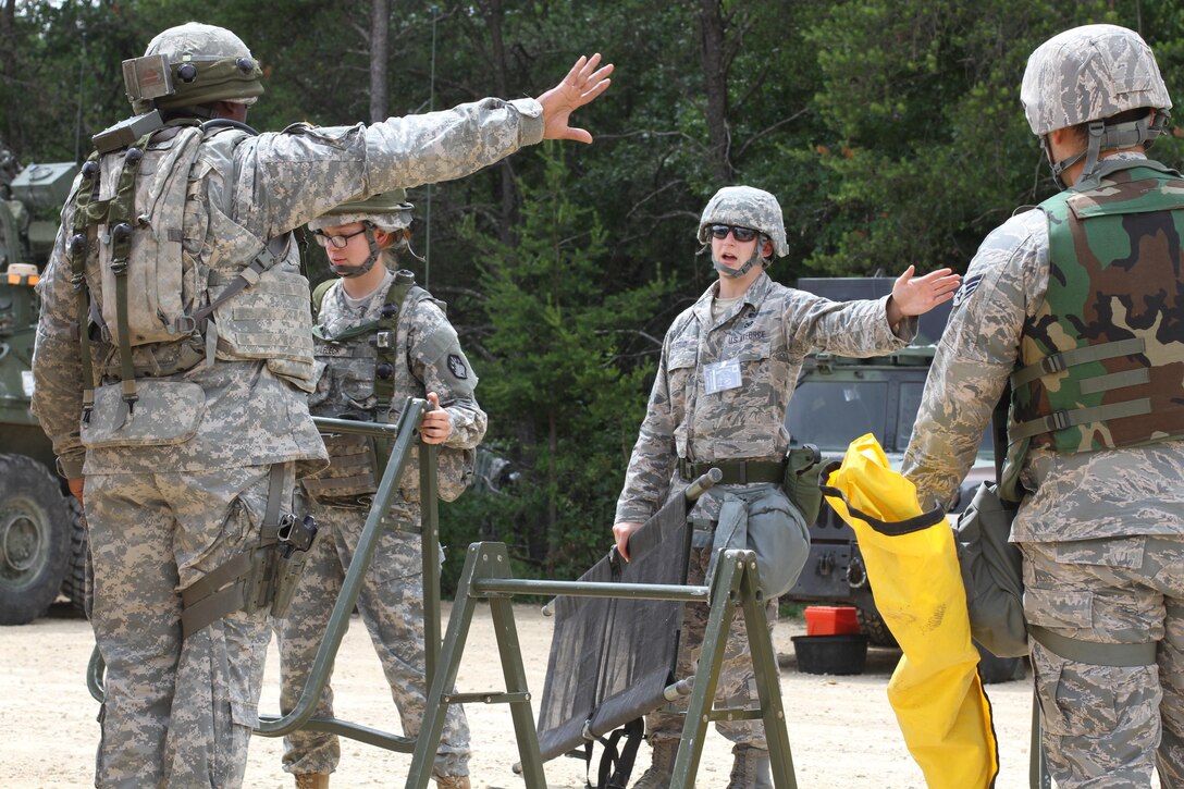 U.S. Army Soldiers assigned to the 46th Chemical Company speak with Senior Airman Derek R. Aalerud, assigned to the 439th Civil Engineering Squadron, to establish hot and cold lines within the contamination control area during a simulated chemical decontamination training exercise at Tactical Training Base Patriot on Fort McCoy, Wis., June 18, 2015. Soldiers and Airmen worked together to improve mission readiness as part of Combat Support Training Exercise (CSTX) 78-15-02. The 78th Training Division’s CSTX is a multi-component and joint endeavor which is integrated with Global Medic and QLLEX and occurring simultaneously at seven installations nationwide.