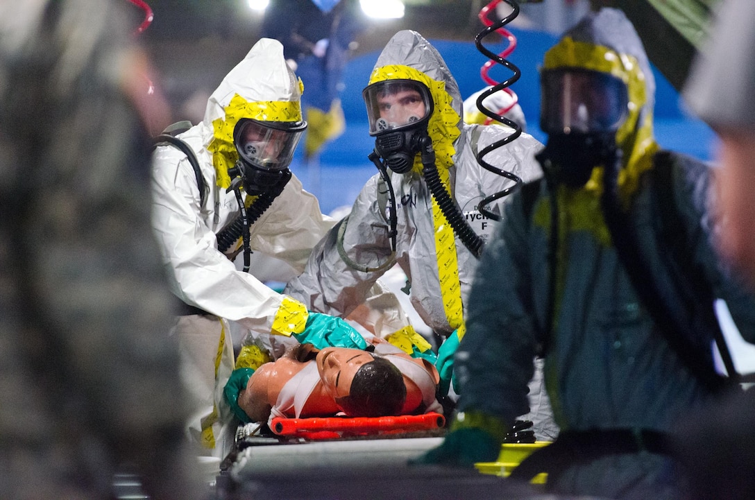 A U.S. Army Reserve Soldier in a hazardous material suits  go through simulated decontamination procedures on mannequins after being exposed to chemicals during Operation Guardian 15, June 25, near Ocala, Fla. More than 500 Army Reserve Soldiers and an active Army unit are participating in the exercise to test their search and rescue, hazardous materials, decontamination, and medical triage capabilities. (U.S. Army photo by Brian Godette/Released)