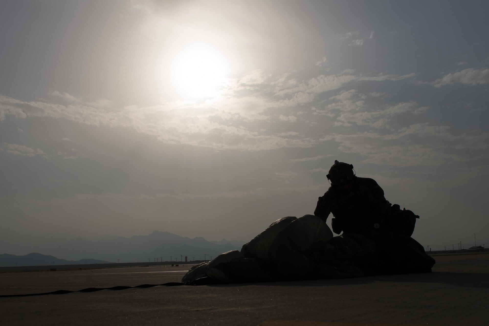 A U.S. Air Force Pararescueman with a Guardian Angel team assigned to the 83rd Expeditionary Rescue Squadron gathers his parachute after landing during High Altitude Low Opening jump training at Bagram Airfield, Afghanistan, July 18, 2015. The 83rd ERQS mission is to rescue, recover, and return American or allied forces in times of danger or extreme duress. (U.S. Air Force photo by Tech. Sgt. Joseph Swafford/Released)