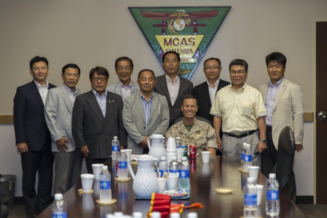 Lt. Col. James Hurd, executive officer for Marine Corps Air Station Futenma, Japan, poses for a group photo with Toshiyuki Kuwabara, center, chairman of the Iwakuni City Council, and other members of the council during a visit to the station to conduct a study tour, July 16, 2015. Chugoku Shikoku Defense Bureau officials, Okinawa Defense Bureau officials and Ginowan City Council members also visited MCAS Futenma to help deepen the their understanding on national security here, and the mission of MCAS Futenma in support of III Marine Expeditionary Force’s aviation warfighting capabilities. 