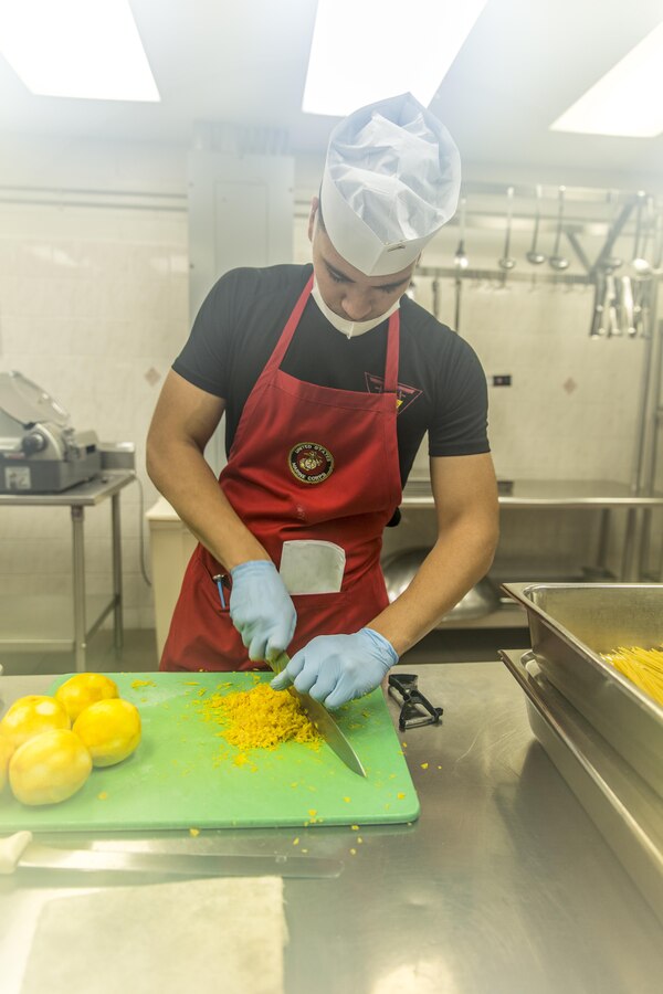 LCpl. Joshua Palacio, a food-service specialist with Headquarters and Headquarters Squadron, Marine Corps Air Station, Marine Corps Installations Pacific, dices orange peels at Futenma Mess Hall, July 14, 2015, aboard MCAS Futenma, Okinawa, Japan. Futenma Mess Hall recently received its fifth consecutive Mess Hall of the Quarter award for overall outstanding performance throughout MCIPAC.  