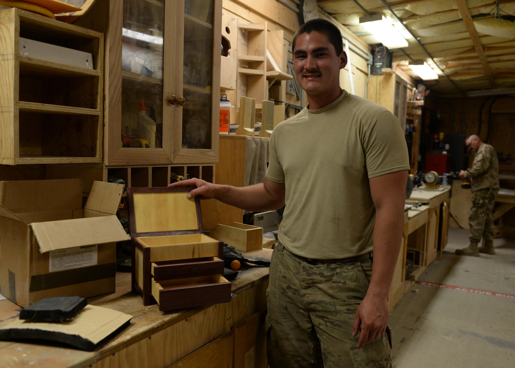 U.S. Air Force Senior Airman Carl Vanlandingham, 455th Expeditionary Civil Engineer Squadron structural journeyman, poses next to a project he built from scratch, July 16, 2015, at Bagram Airfield, Afghanistan. Vanlandingham builds various projects during duty and on his days off to support the mission here. (U.S. Air Force photo by Senior Airman Cierra Presentado/Released)