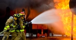 Firefighters from the 181st and the 317th Engineer Detachment, Nebraska Army National Guard, spray water during an aircraft rescue and fire burn as they prepare for the annual PATRIOT Exercise at Volk Field Combat Readiness Training Center, Wisconsin, July 16, 2015. PATRIOT is a domestic operations disaster-response training exercise conducted by National Guard units working with federal, state and local emergency management agencies and first responders.