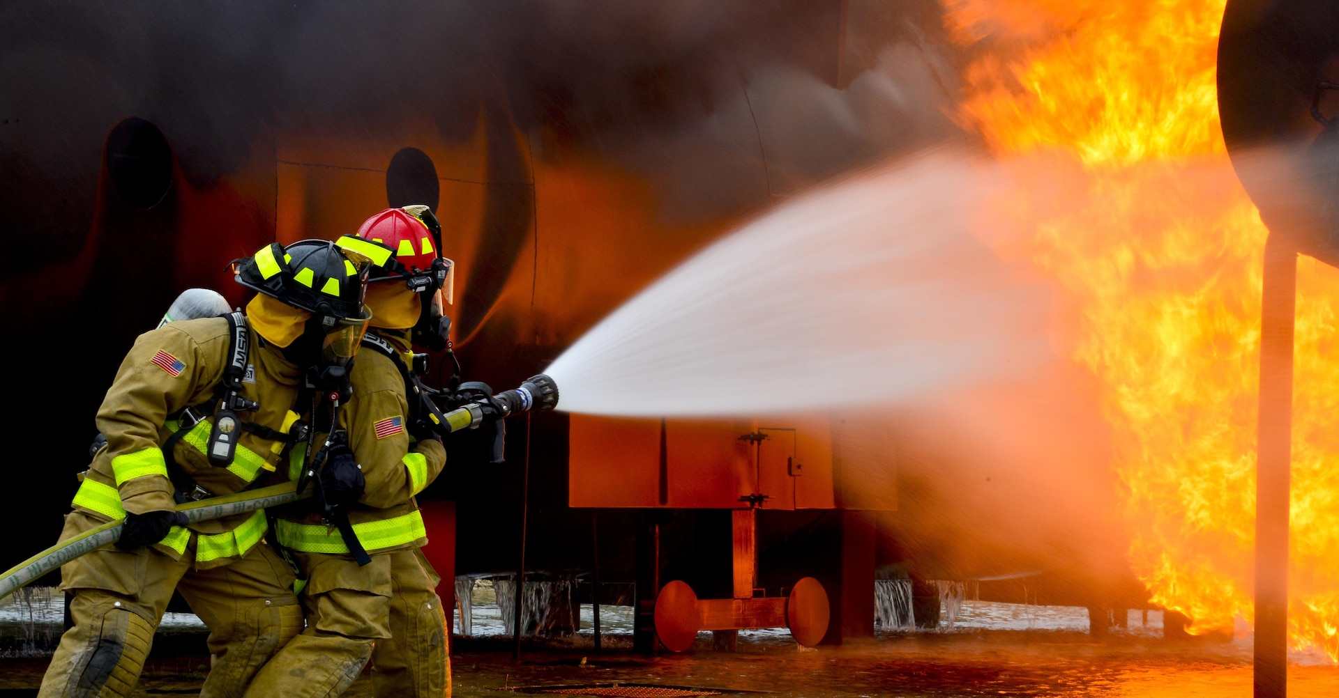 Firefighters from the 181st and the 317th Engineer Detachment, Nebraska Army National Guard, spray water during an aircraft rescue and fire burn as they prepare for the annual PATRIOT Exercise at Volk Field Combat Readiness Training Center, Wisconsin, July 16, 2015. PATRIOT is a domestic operations disaster-response training exercise conducted by National Guard units working with federal, state and local emergency management agencies and first responders.