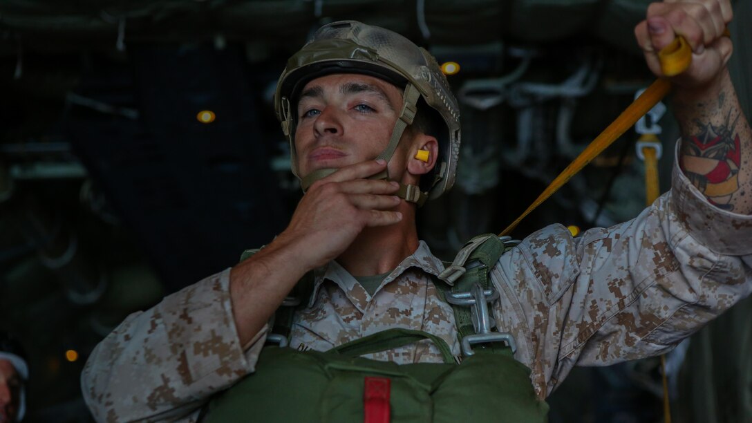 A Marine assigned to Company A, 1st Marine Reconnaissance Battalion, 1st Marine Division, conducts his final gear inspections before performing a parachute jump into the ocean at Marine Corps Base Camp Pendleton, California, July 15, 2015.  The Marines and Sailors conducted low-level static-line parachute operations with intentional water landings to make insertions, where other means such as boats or high-altitude parachute jumps may not be available.