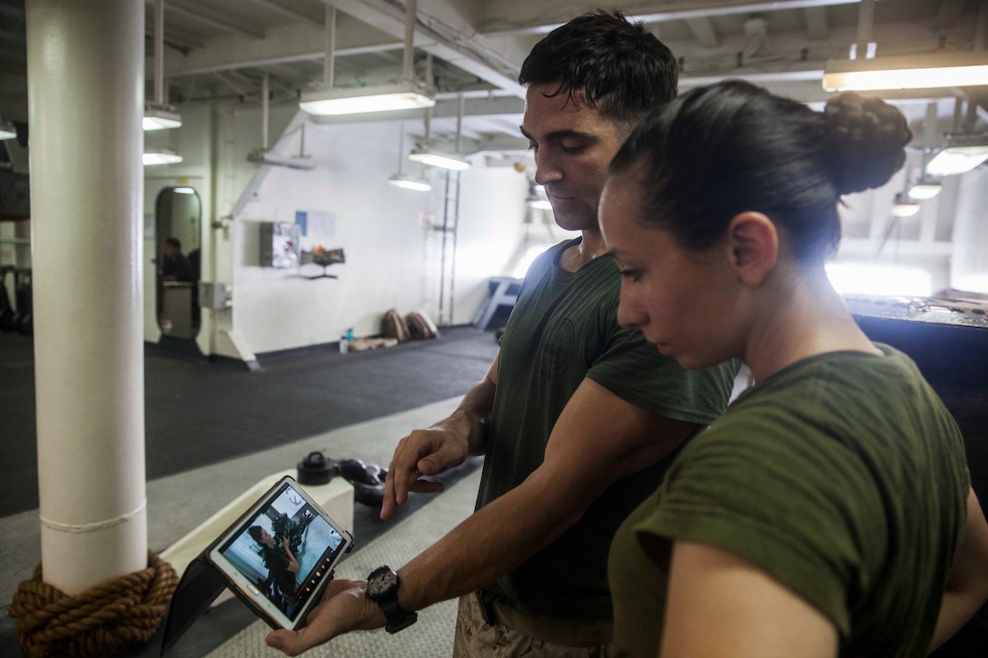 U.S. Marine Sgt. Sean Bernstein, left, shows Lance Cpl. Chevon Ferrel a video of a speed reload aboard the amphibious assault ship USS Essex (LHD 2). Bernstein is a member of the 15th Marine Expeditionary Unit’s Maritime Raid Force and Ferrel is an ammunition technician with Combat Logistics Battalion 15, 15th MEU. The Marines watch videos of themselves practicing drills to correct deficiencies they may not otherwise notice. The 15th MEU is embarked on the Essex Amphibious Ready Group and deployed to maintain regional security in the U.S. 5th Fleet area of operations. 
