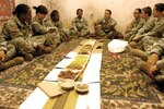 Members of the 2nd Battalion, 108th Infantry Regiment’s Female Engagement Team learn how to dine politely during an Afghan meal during pre-mobilization training May 31 in Fort Drum. The 10-person FET will act as cultural mediators when deployed to Iraq, which means they will go on combat missions with the 27th Infantry Brigade Combat Team, march and fight as they do, and then talk to Afghan women in an effort to understand their concerns.