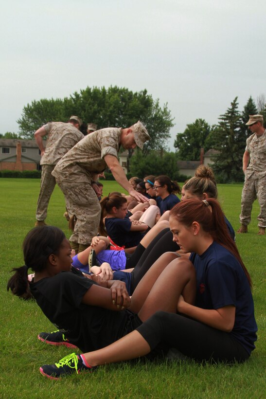 Recruiting Station Detroit’s female Marine poolees perform crunches during the bi-annual female pool function at the Boys and Girls Club of Troy, Michigan, June 20, 2015. The ladies started the day off with an Initial Strength Test that includes three events: pull-ups or a flexed arm hang, crunches, and a 1.5 mile run for time. (U.S. Marine Corps photo by Cpl. J.R. Heins/Released)