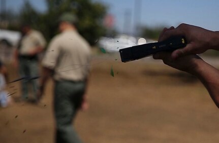Military police and civilian law enforcement officers with the Marine Corps Air Station Miramar Provost Marshals Office (PMO) fire the Taser X26 during their annual Taser training aboard MCAS Miramar, California, July 15. The training helped familiarize the law enforcement personnel with standardized procedures for employing nonlethal weapons. (U.S. Marine Corps photo by Sgt. Brian Marion/Released)