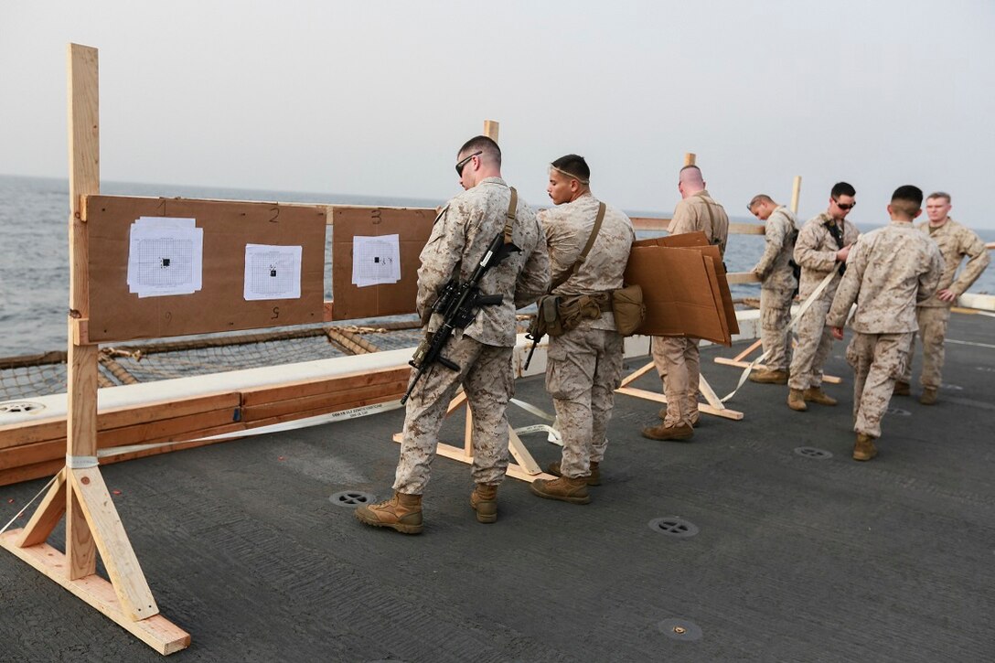 U.S. Marines with Light Armored Reconnaissance Detachment, Battalion Landing Team 3rd Battalion, 1st Marine Regiment, 15th Marine Expeditionary Unit break down targets after battle-sight zeroing their weapons on the flight deck of the amphibious transport dock ship USS Anchorage (LPD 23). The Marines with LAR Detachment are part of the ground combat element of the 15th MEU, and embarked aboard the ships of the Essex Amphibious Ready Group, are deployed in support of maritime security operations and theater security cooperation efforts in the U.S. 5th Fleet area of operations. (U.S. Marine Corps photo by Sgt. Steve H. Lopez/Released)