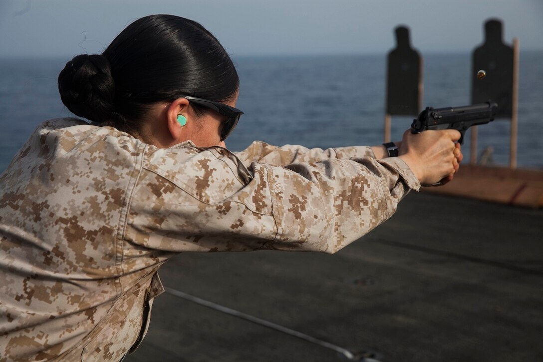 U.S. Marine Sgt. Jeanette Ventura fires at her target during a deck shoot aboard the amphibious assault ship USS Essex (LHD 2). Ventura is an airframes mechanic with Marine Medium Tiltrotor Squadron 161 (Reinforced), 15th Marine Expeditionary Unit. These Marines executed a pistol qualification during Female Engagement Team training. The 15th MEU is embarked on the Essex Amphibious Ready Group and deployed to maintain regional security in the U.S. 5th Fleet area of operations. (U.S. Marine Corps photo by Cpl. Anna Albrecht/Released)