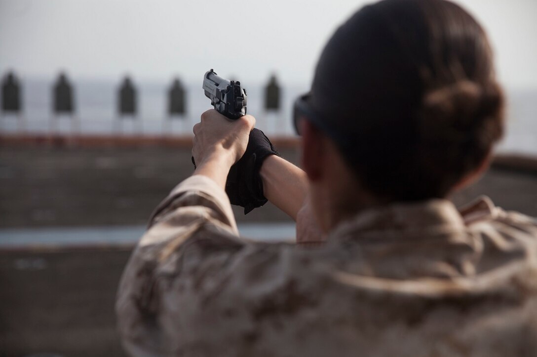 U.S. Marine Cpl. Elize McKelvey shoots at her target with an M9 Beretta pistol during a deck shoot aboard the amphibious assault ship USS Essex (LHD 2). McKelvey is a production specialist with the 15th Marine Expeditionary Unit’s Command Element. These Marines executed a pistol qualification during Female Engagement Team training. The 15th MEU is embarked on the Essex Amphibious Ready Group and deployed to maintain regional security in the U.S. 5th Fleet area of operations. (U.S. Marine Corps photo by Cpl. Anna Albrecht/Released)