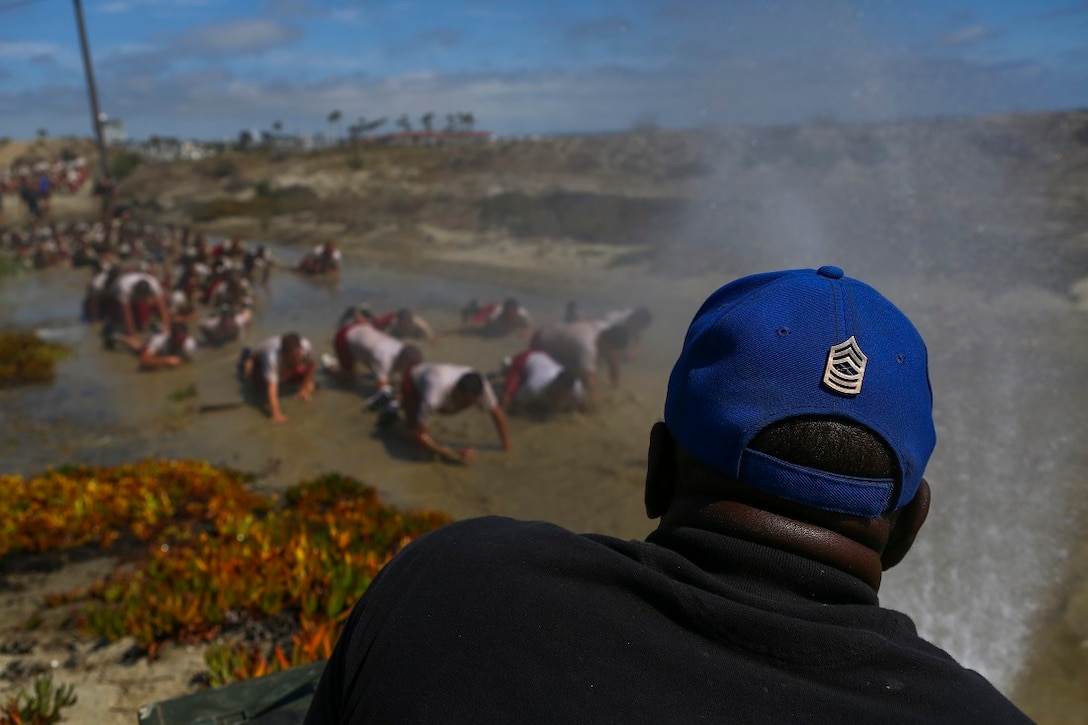 Master Sgt. Keith Porter (Ret.), a staff member with the Devil Pups sprays a group of Devil Pups with a hose during a mud run aboard Marine Corps Base Camp Pendleton, Calif., July 12, 2015. After the run, Marines assigned to 1st Reconnaissance Battalion, 1st Marine Division, demonstrated their amphibious capabilities and answered questions the Devil Pups had about the recon community. (U.S. Marine Corps photo by Cpl. Will Perkins)