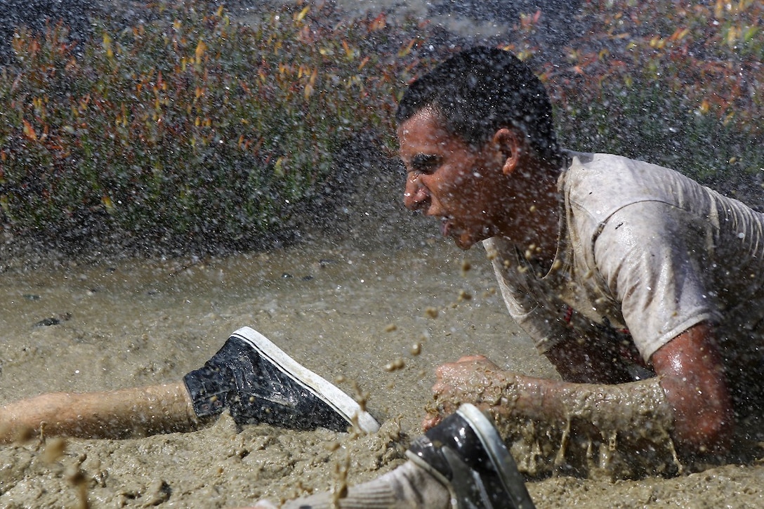 A Devil Pup low-crawls through water while being sprayed by a hose during a mud run aboard Marine Corps Base Camp Pendleton, Calif., July 12, 2015. After the run, Marines assigned to 1st Reconnaissance Battalion, 1st Marine Division, demonstrated their amphibious capabilities and answered questions the Devil Pups had about the recon community. (U.S. Marine Corps photo by Cpl. Will Perkins)