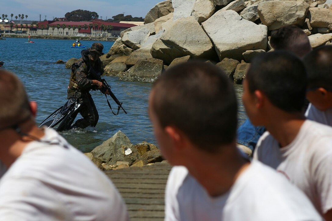 A reconnaissance Marine with 1st Reconnaissance Battalion, 1st Marine Division, demonstrates 1st Recon’s amphibious capabilities to Devil Pups aboard Marine Corps Base Camp Pendleton, Calif., July 12, 2015. After the demonstration, the Marines held a question and answer session for the students who wanted to know more about the reconnaissance community. (U.S. Marine Corps photo by Cpl. Will Perkins)