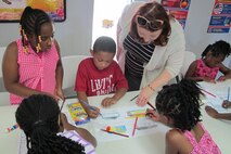 Stacey Sapp, of the Engineering and Support Center, Huntsville, talk with students about color schemes during interior design activity June 19. 