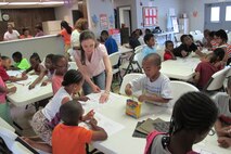 Erin Hamilton, of the Engineering and Support Center, Huntsville, shows students  interior design concepts June 19. 