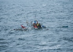 SOUTH CHINA SEA (July 19, 2015) Distressed fishermen await rescue from their sinking fishing boat by the Military Sealift Command ocean surveillance ship USNS Impeccable (T-AGO-23). Eleven fishermen were rescued from the partially submerged boat. 