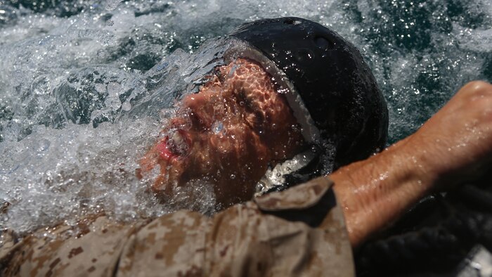 A Marine assigned to Company A, 1st Marine Reconnaissance Battalion, 1st Marine Division, holds onto the side of a combat rubber raiding craft after completing a parachute jump into the ocean at Marine Corps Base Camp Pendleton, California, July 14, 2015.  The Marines and Sailors conducted low-level static-line parachute operations with intentional water landings to make insertions, where other means such as boats or high-altitude parachute jumps may not be available.