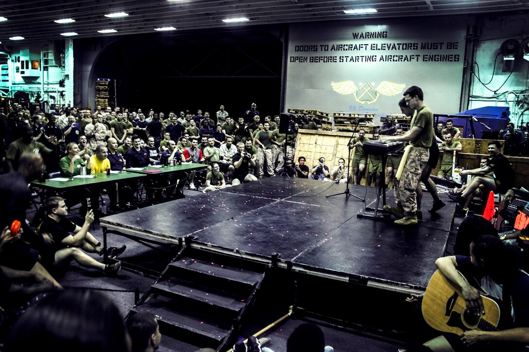 GULF OF ADEN (July 12, 2015) U.S. Marines with the 15th Marine Expeditionary Unit entertain the crowd by performing a duet on a piano during a talent show in the hangar bay of the amphibious assault ship USS Essex (LHD 2). The Essex finds time to enhance unit moral by highlighting Marines and Sailors with the 15th MEU and Essex Amphibious Ready Group’s talents during their deployment. The 15th MEU is embarked on the Essex ARG and deployed to maintain regional security in the U.S. 5th Fleet area of operations. (U.S. Marine Corps photo by Cpl. Elize McKelvey/Released)