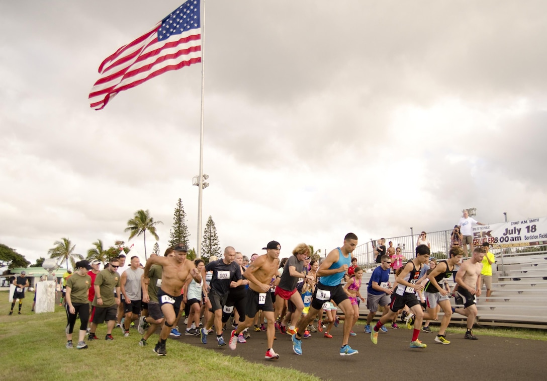 The participants of the Camp Smith Grueler 5K begin the race at Bordelon Field aboard Camp H.M. Smith, July 18, 2015. The race, which was part of the Commanding Officer’s Fitness Series, began and ended at Bordelon Field. Participants ran a portion of the race through a trail. Service members aboard Marine Corps Base Hawaii could also earn points for their unit toward the 101 Days of Summer Program by participating in the Grueler. (U.S. Marine Corps photo by Kristen Wong/Released)