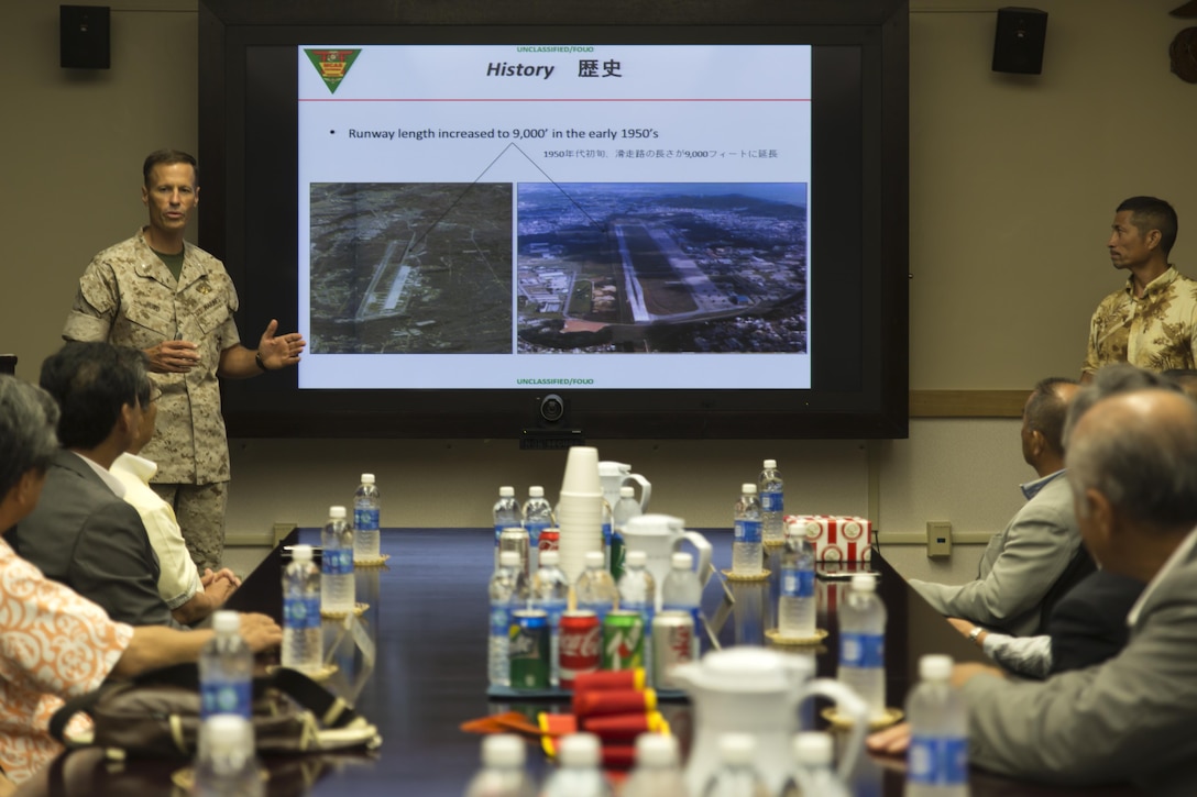 Lt. Col. James Hurd, executive officer for Marine Corps Air Station Futenma, Okinawa, Japan, Marine Corps Installations Pacific, gives a command brief to Chugoku Shikoku Defense Bureau  officials, Okinawa Defense Bureau officials, Iwakuni City assembly members and Ginowan City Council members during a visit to the station to conduct a study tour, July 16, 2015. The purpose was to help deepen the distinguished guests’ understanding on national security here, and the mission of MCAS Futenma in support of III Marine Expeditionary Force’s aviation warfighting capabilities.