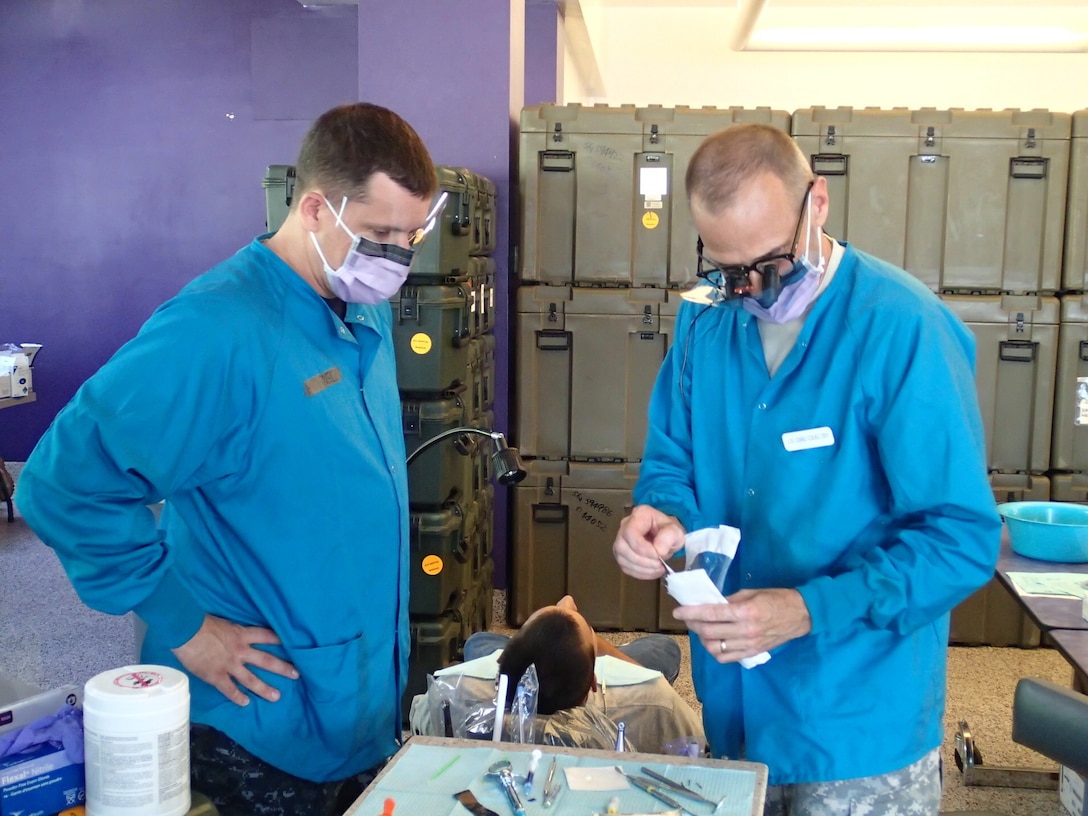 Lt. Col. Craig Colas, right, a dentist from U.S. Army Dental Activity, and Seaman Bryan Igneczi, a hospitalman from EMF Bethesda, prepare dental tools prior to treatment at Greater Chenango Cares on July 16, 2015. Greater Chenango Cares is one of the Innovative Readiness Training missions which provides real-world training in a joint civil-military environment while delivering world class medical care to the people of Chenango County, N.Y., from July 13-23. (U.S. Army photo by Sgt. Jennifer Shick/released)