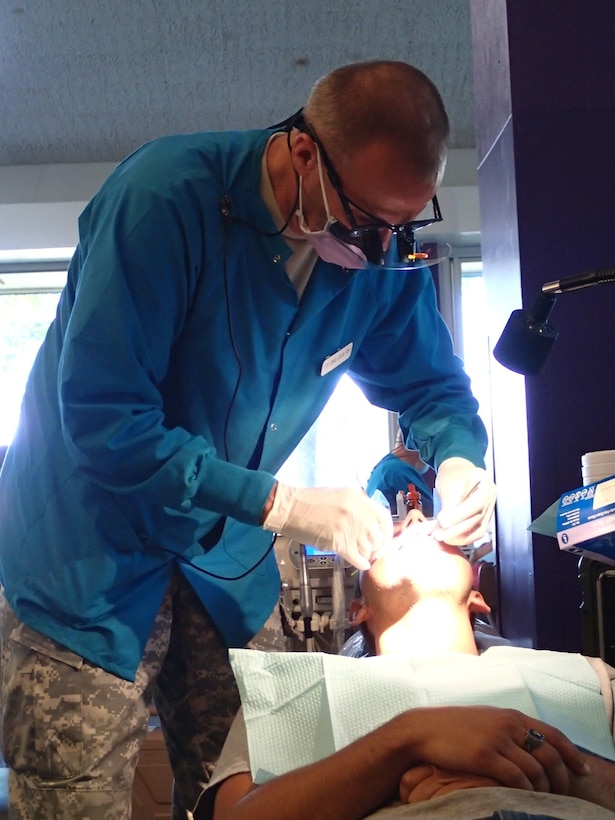 Lt. Col. Craig Colas, a dentist from U.S. Army Dental Activity provides dental treatment at Greater Chenango Cares on July 16, 2015. Greater Chenango Cares is one of the Innovative Readiness Training missions which provides real-world training in a joint civil-military environment while delivering world class medical care to the people of Chenango County, N.Y., from July 13-23. (U.S. Army photo by Sgt. Jennifer Shick/released)