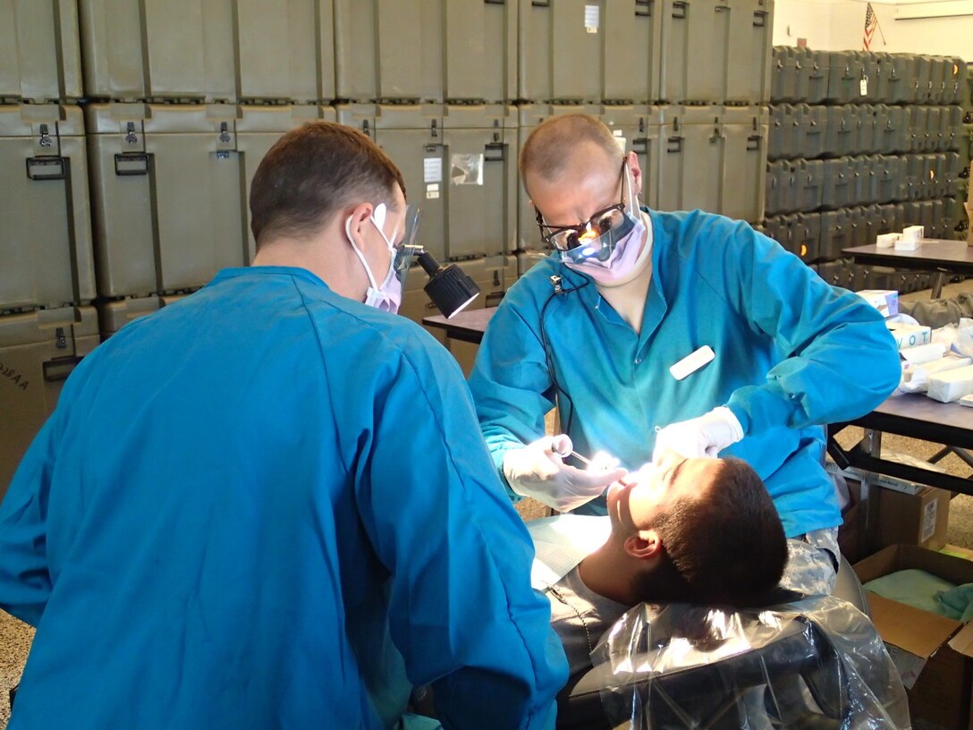 Lt. Col. Craig Colas, right, a dentist from U.S. Army Dental Activity, and Seaman Bryan Igneczi, a hospitalman from EMF Bethesda, provide dental treatment at Greater Chenango Cares on July 16, 2015. Greater Chenango Cares is one of the Innovative Readiness Training missions which provides real-world training in a joint civil-military environment while delivering world class medical care to the people of Chenango County, N.Y., from July 13-23. (U.S. Army photo by Sgt. Jennifer Shick/released)