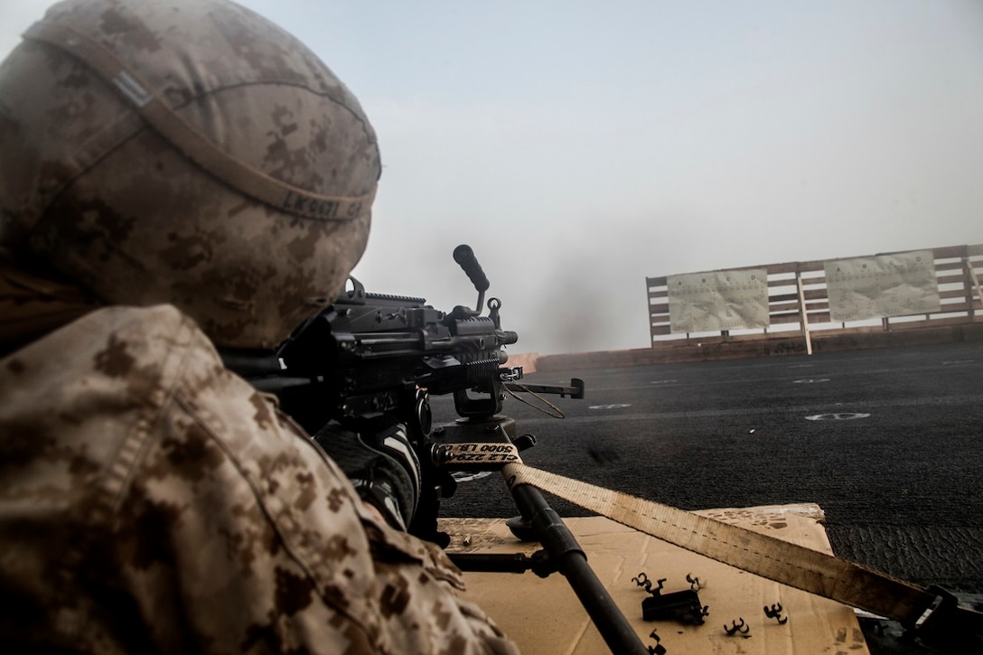 GULF OF ADEN (July 14, 2015) U.S. Marine Lance Cpl. Tyler Knotts sends rounds through his target with an M240B machine gun on the flight deck of the amphibious assault ship USS Essex (LHD 2). Knotts is a machine gunner with Lima Company, Battalion Landing Team 3rd Battalion, 1st Marine Regiment, 15th Marine Expeditionary Unit. The 15th MEU is embarked on the Essex Amphibious Ready Group and is deployed to maintain regional security in the U.S. 5th Fleet area of operations.  (U.S. Marine Corps photo by Cpl. Elize McKelvey/Released)