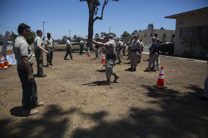 Military police and civilian law enforcement officers with the Marine Corps Air Station Miramar Provost Marshals Office (PMO) practice employing the Taser X26 during annual Taser training aboard MCAS Miramar, California, July 15. The training helped familiarize the law enforcement personnel with standardized procedures for employing nonlethal weapons. (U.S. Marine Corps photo by Sgt. Brian Marion/Released)